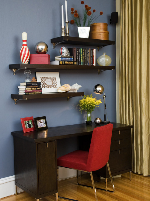 Contemporary small home office in blue and red featuring floating shelves and silk draperies.