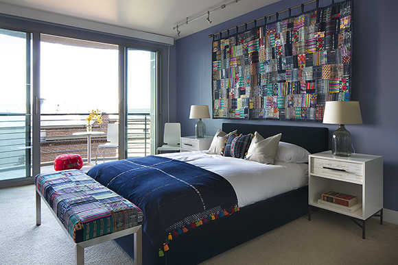 Masculine bedroom in blues and whites with a Guatamalan blanket over the bed