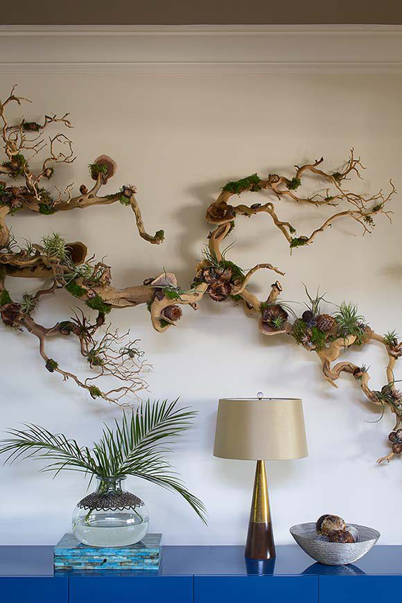 Photo of how a beautiful natural manzanita branch mounted on the wall makes a lovely display over a table with lamp.