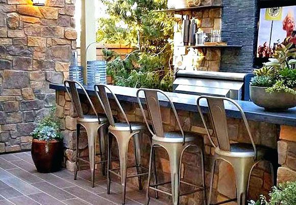 Outdoor home bar featuring natural flagstone, tiled flooring, metal counter height barstools, lots of countertop space and plenty of potted succulents to make it a hidden delight.