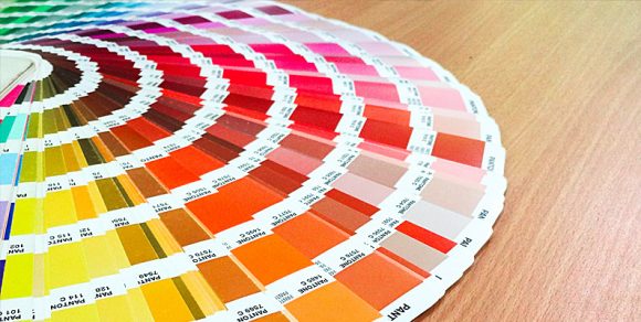 Fan deck of multiple paint colors spread out on a table surface.