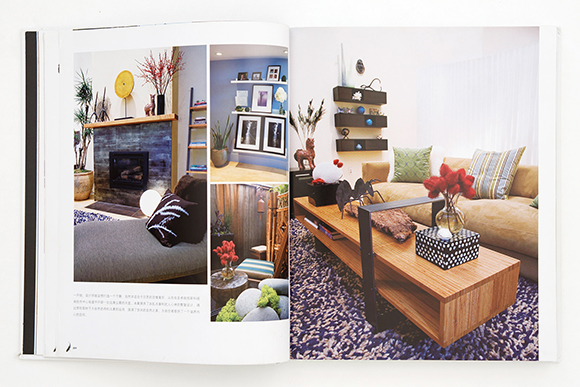 Photo of an open book showing 2-page spread with colorful photos of a living room fireplace and chaise lounge, a coffee table, sofa, and shelving, and a small outdoor space.