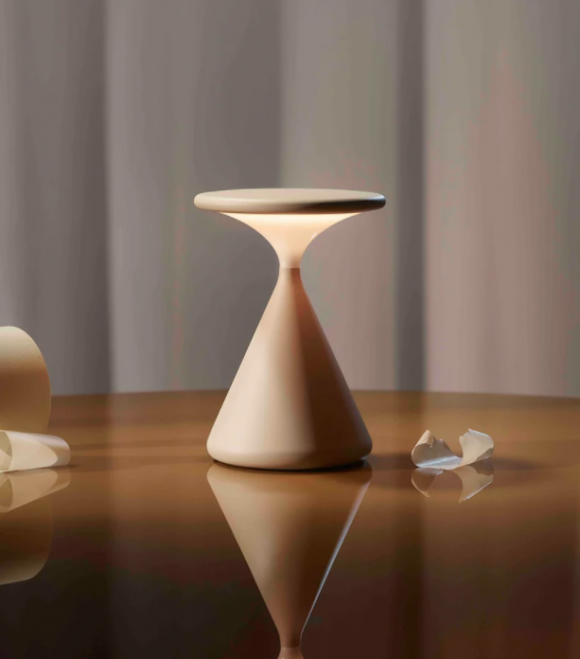 A portable lamp that looks like an hourglass with a shorter, flattened top. The top half of the spindle shape lights up.