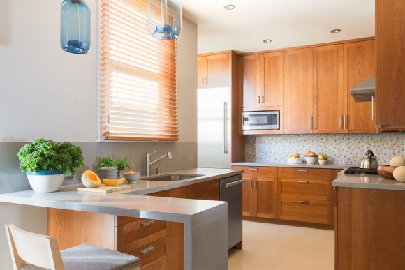 A warm kitchen with easy-to-clean countertops and backsplash tiling.