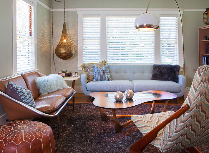 George Nelson sling sofa mixes with an arc lamp and Moroccan pendant for a vintage global living area.