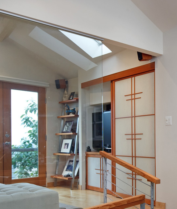 Built-in entertainment alcove with sliding doors in off-white and red-colored wood, and open shelving to the left side