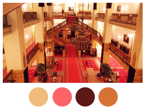 Scene from the film "The Grand Budapest Hotel", showing the lobby with 4 colors picked out in circles below as palette highlights