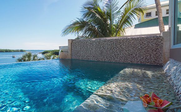 This infinity pool with a pebbled underwater sofa was originally designed by Bradenton Golf & Custom Pools for a famous family and restored by Lucas Lagoons.