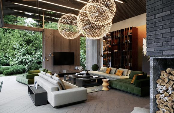 Indoor/outdoor living room with moss-green tufted sofas, reddish-brown wood cabinetry, brown wall with TV screen, and a triple pendant light in the shape of white globes that resemble lens flares or snowflakes. A dark brick wall with firewood storage appears at the far right.