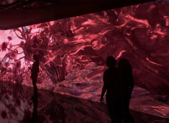 The outlines of people in shadow standing against an illuminated wall  of organic plant-like steams reaching out and unfurling, in the Viva Magenta color.