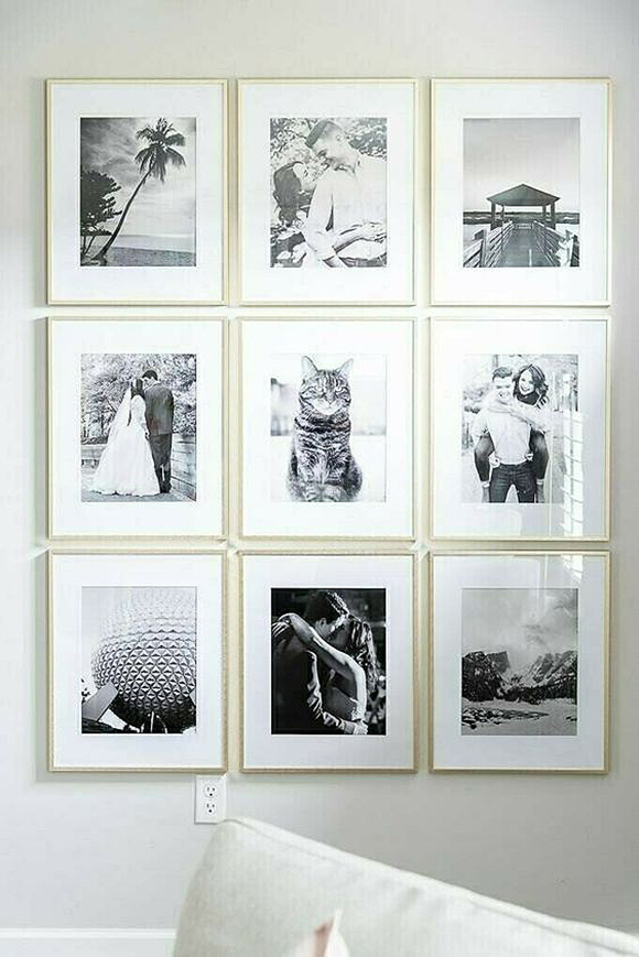 A wall display showing 9 gold-framed black and white photos with medium white matting, aligned into 3 rows of 3.