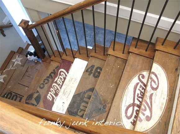 As seen from above, a country store-style staircase is painted with multiple signage logos such as Pepsi-Cola, Texaco, and Coca-Cola across one to two treads each logo.